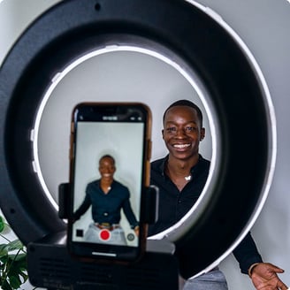 Content creator using a ring light while filming for social channels