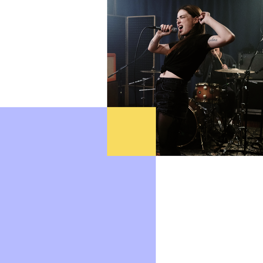 Studio session with woman vocalist and drummer, creating tracks for licensing music for advertising.