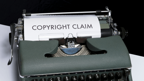 Close up of a green typewriter typing social media copyright infringement cases