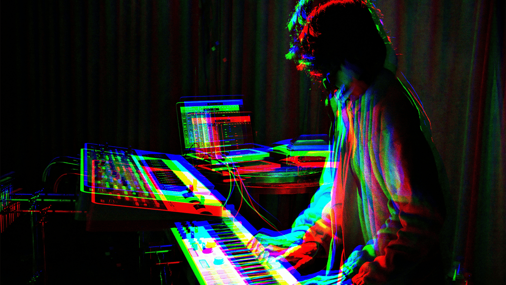 A man playing an electronic keyboard, considering how good music vs bad music affects a brand sound