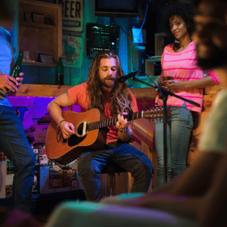 A man playing indie guitar, creating royalty free music for movies soundtracks and videos.