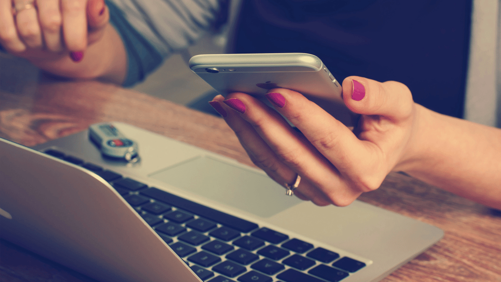 Woman using a silver iPhone for business use of social media