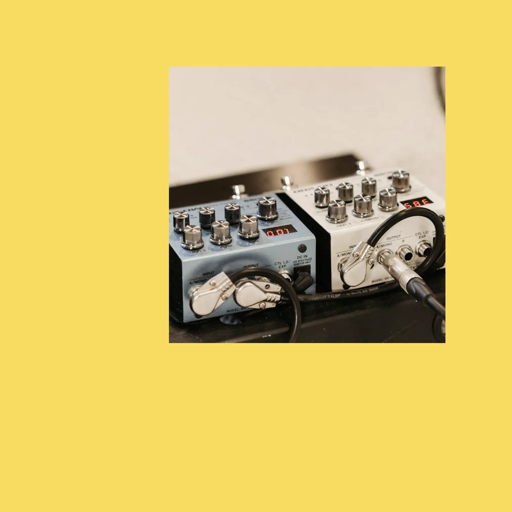 Two plugs for amps to create premium royalty free music with Soundstripe on yellow background